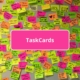 Viele beschriebende Klebezettel an einer Wand und Schrift TaskCards