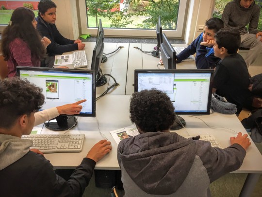 SchülerInnen vor Rechnern am Tisch